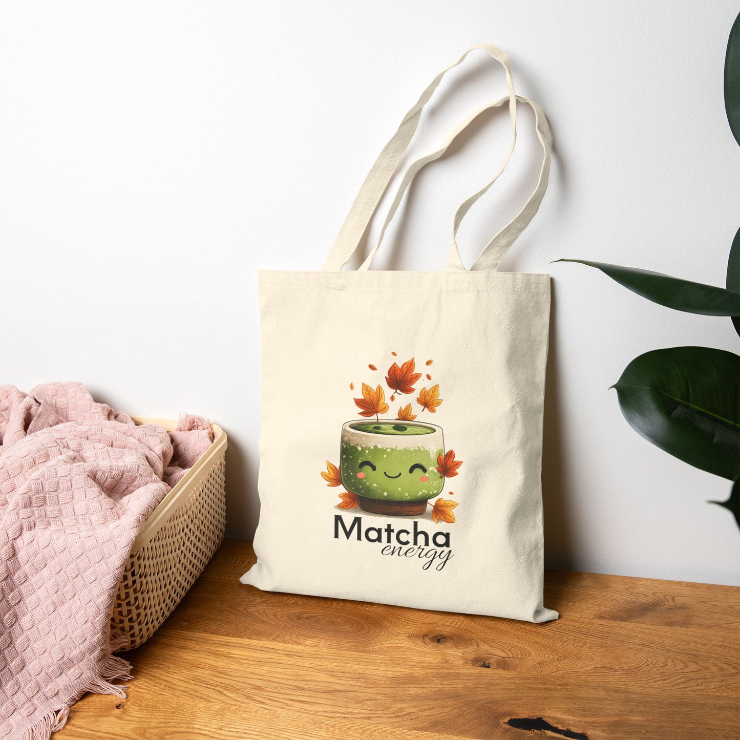 Tote bag with a matcha-themed design on a wooden surface with a white wall background.