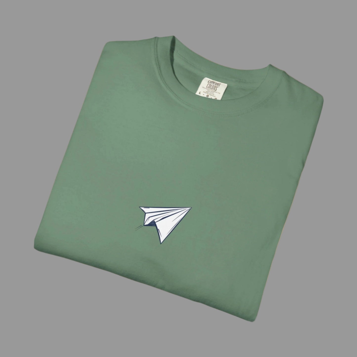 Folded green t-shirt with a white paper airplane design on a white background