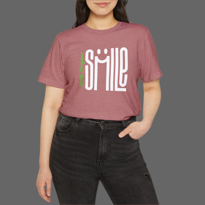 Person wearing a maroon t-shirt with 'SMILE' printed on it against a white background