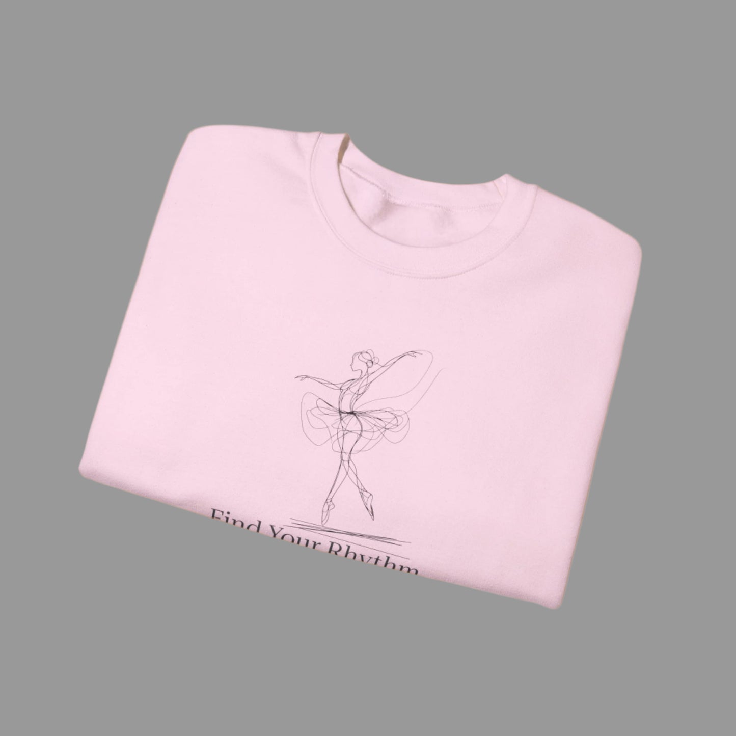 Folded pink sweatshirt with a graphic of a dancer and text 'Find Your Rhythm' on a white background