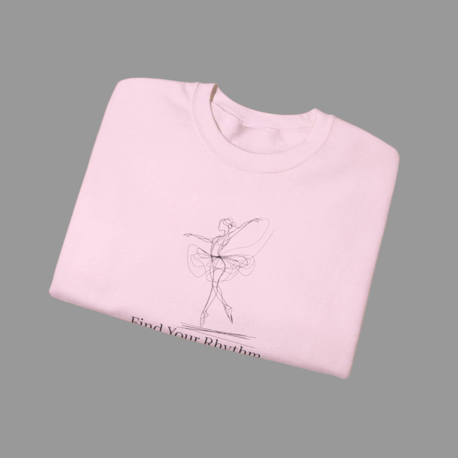 Folded pink sweatshirt with a graphic of a dancer and text 'Find Your Rhythm' on a white background