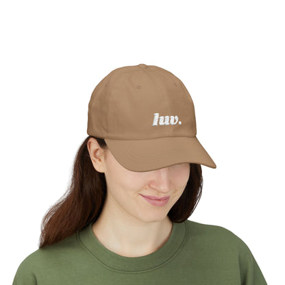 Person wearing a brown cap with 'huv.' logo on a white background