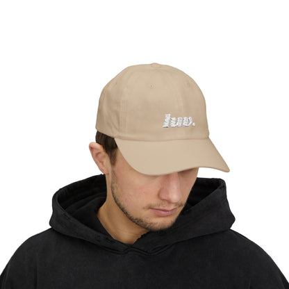 Man wearing a beige cap with a logo on a white background