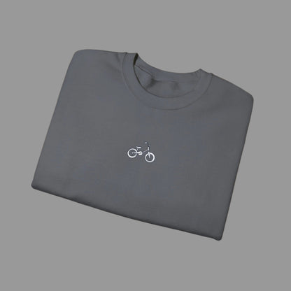 Folded gray t-shirt with a small bicycle logo on a white background