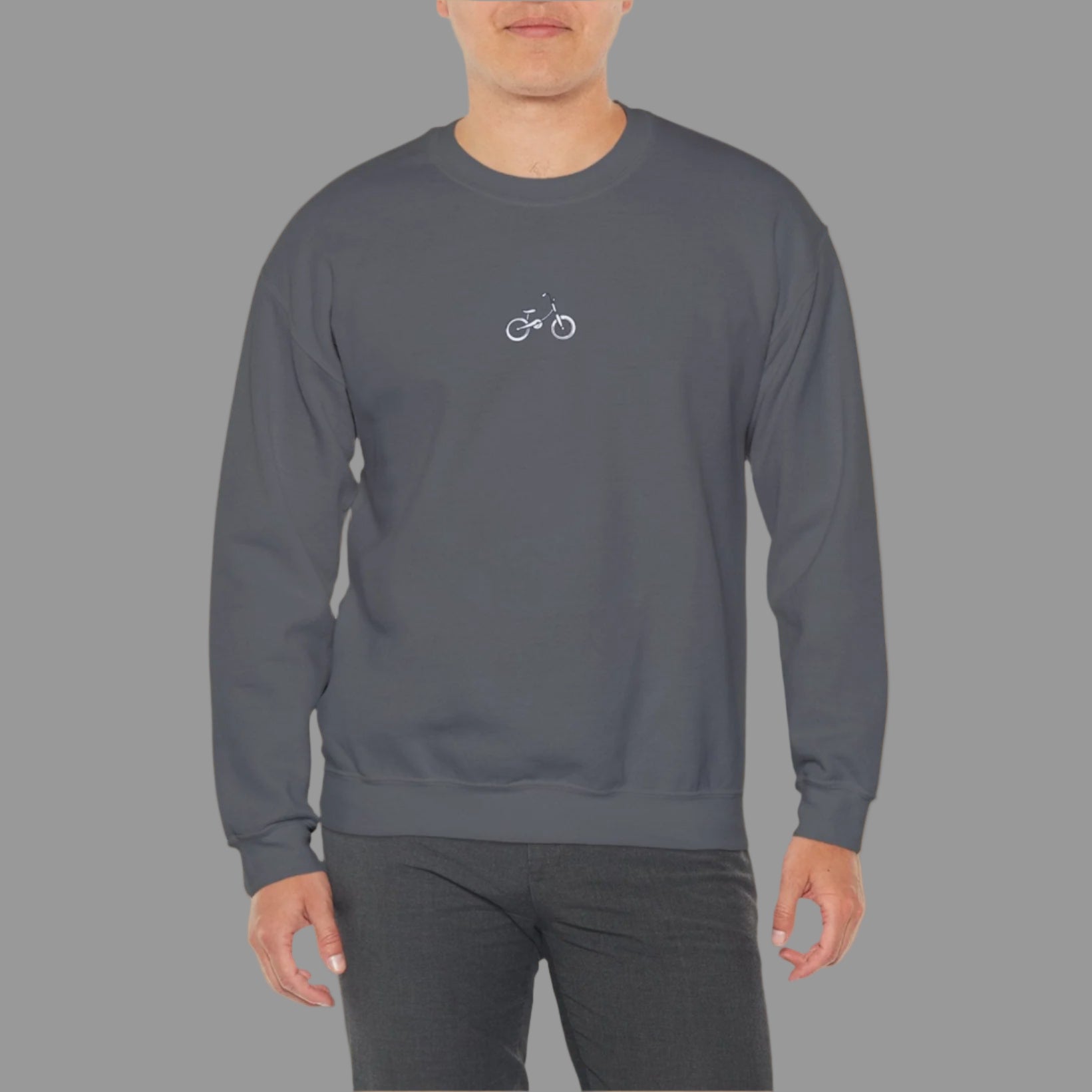 Man wearing a gray sweatshirt with a small logo on a white background