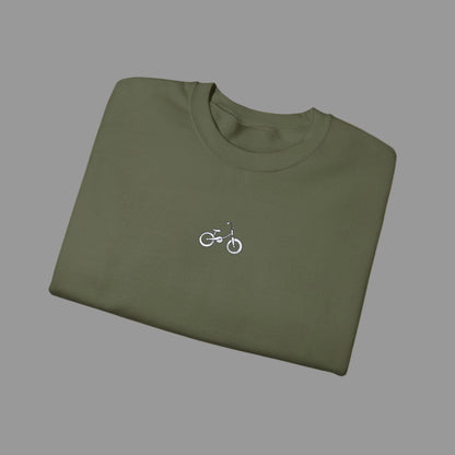 Folded green t-shirt with a small bicycle logo on a white background