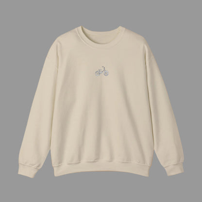Beige sweatshirt with a small graphic on the chest against a white background