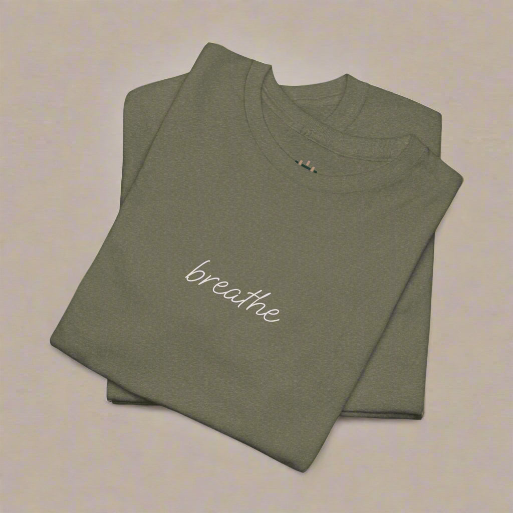 Folded olive green t-shirt with 'breathe' text on a white background