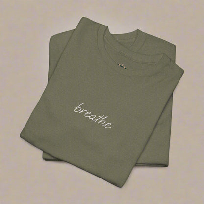 Folded olive green t-shirt with 'breathe' text on a white background
