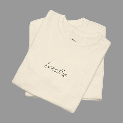 Folded beige t-shirt with 'breathe' text on a white background