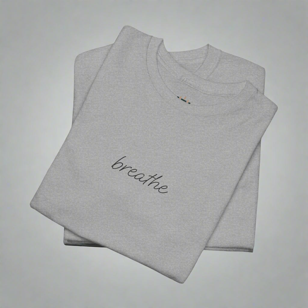 Folded gray t-shirt with 'breathe' text on a white background