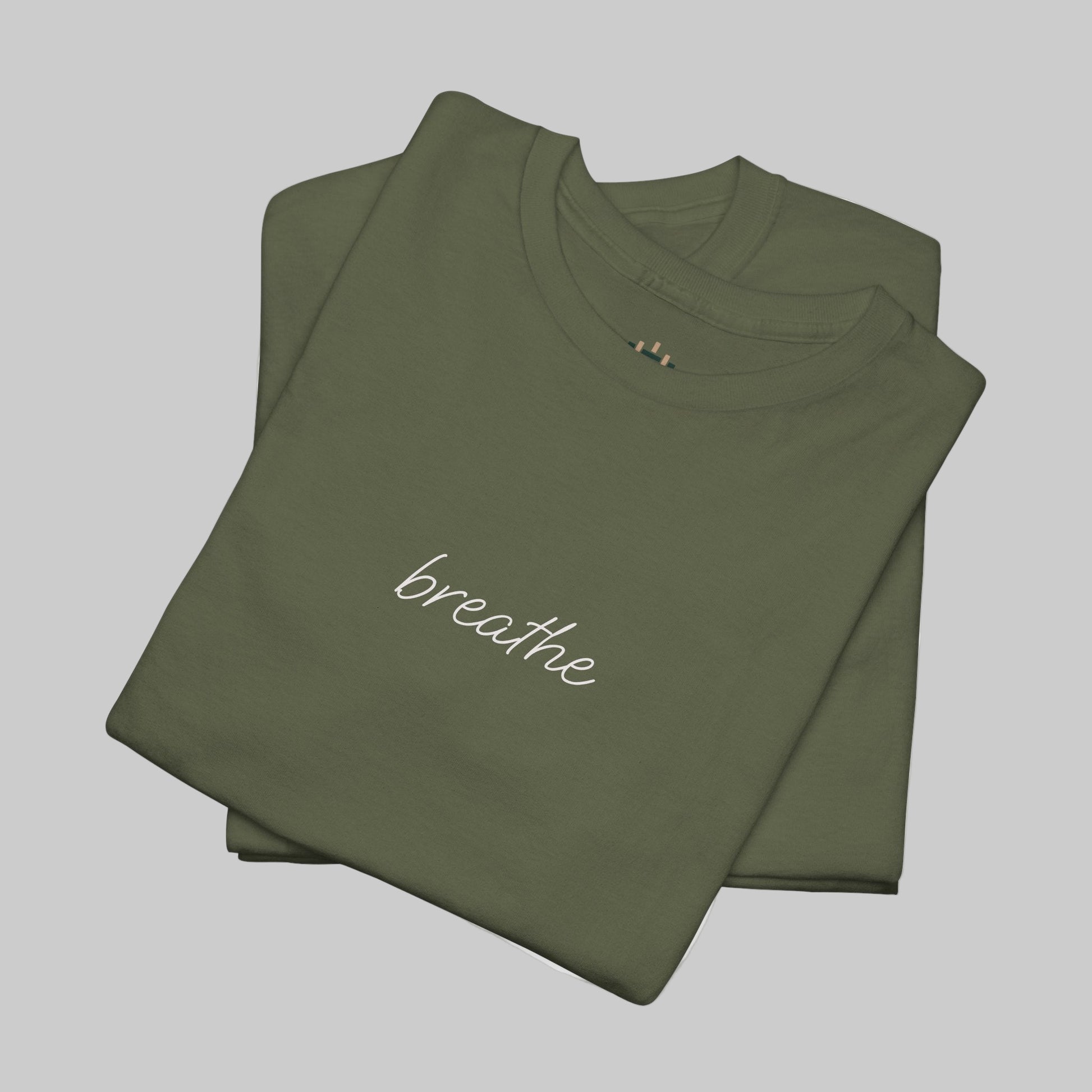 Folded green t-shirt with 'breathe' text on a white background