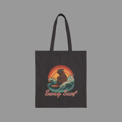 Black tote bag with a bear surfing design and 'Swag Surf' text on a white background