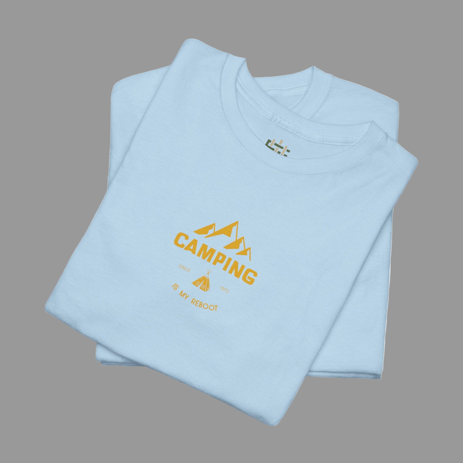 Folded light blue t-shirt with yellow 'Camping' text on a white background
