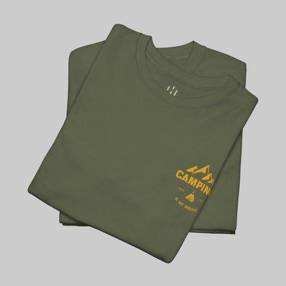 Folded green t-shirt with yellow 'Camping' logo on a white background