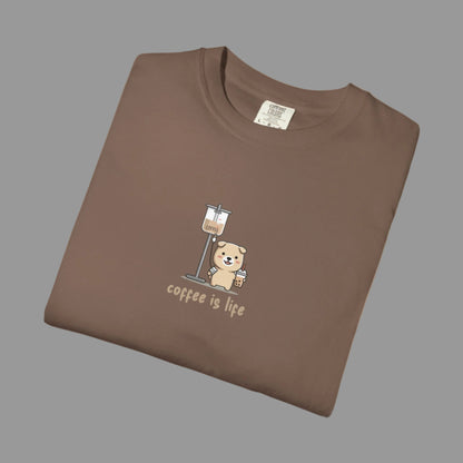 Folded brown t-shirt with a bear and coffee cup graphic and 'coffee is life' text on a white background