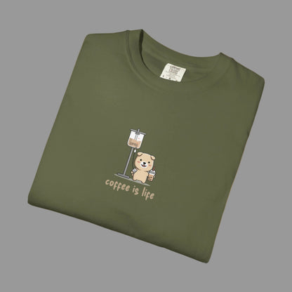 Folded green t-shirt with a bear and coffee cup graphic and 'coffee is life' text on a white background