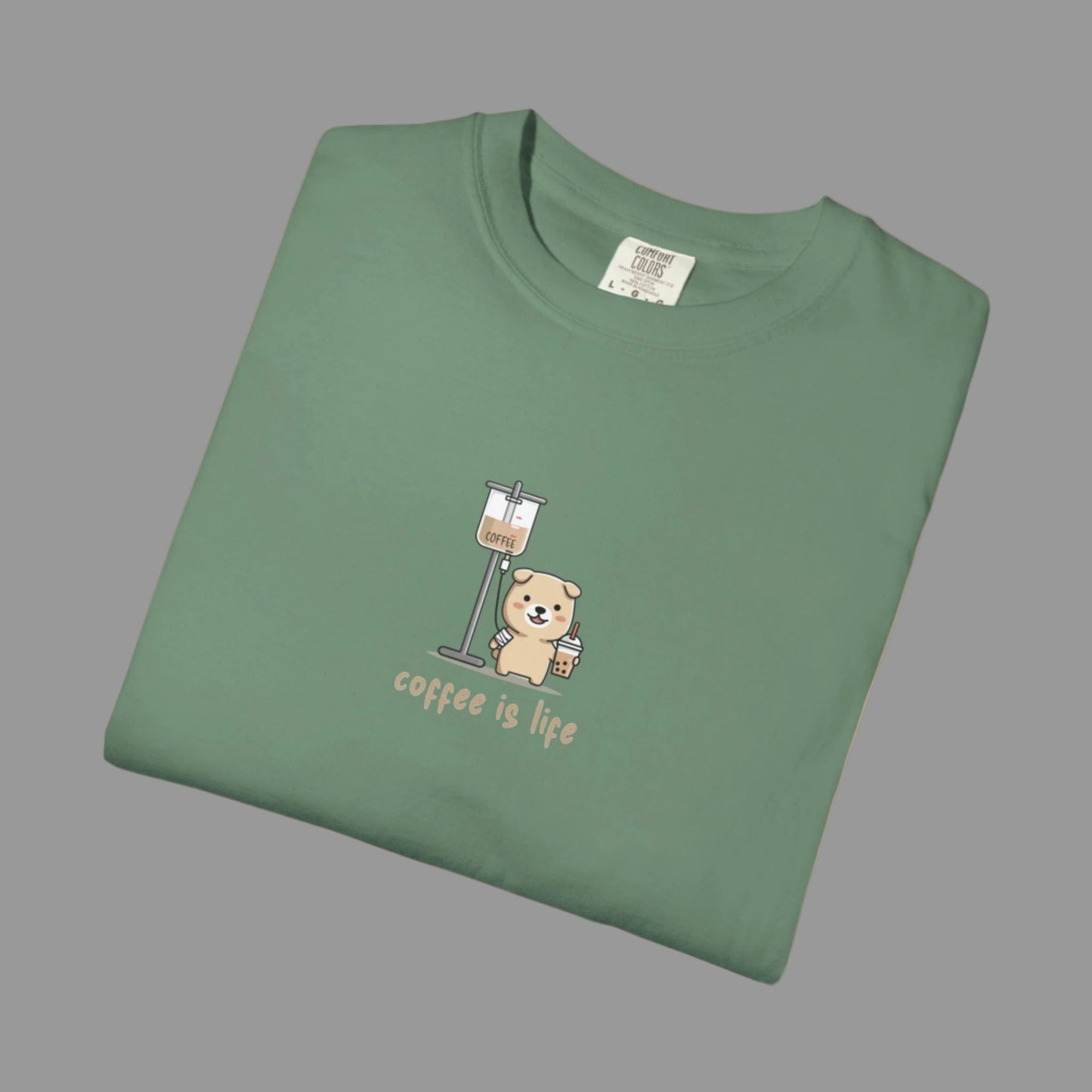 Folded green t-shirt with a bear and coffee cup graphic and 'coffee is life' text on a white background.
