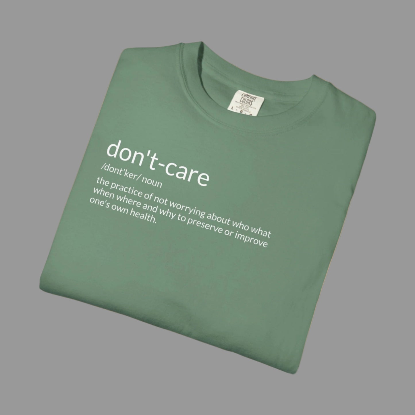 Folded green t-shirt with 'don't-care' text on a white background