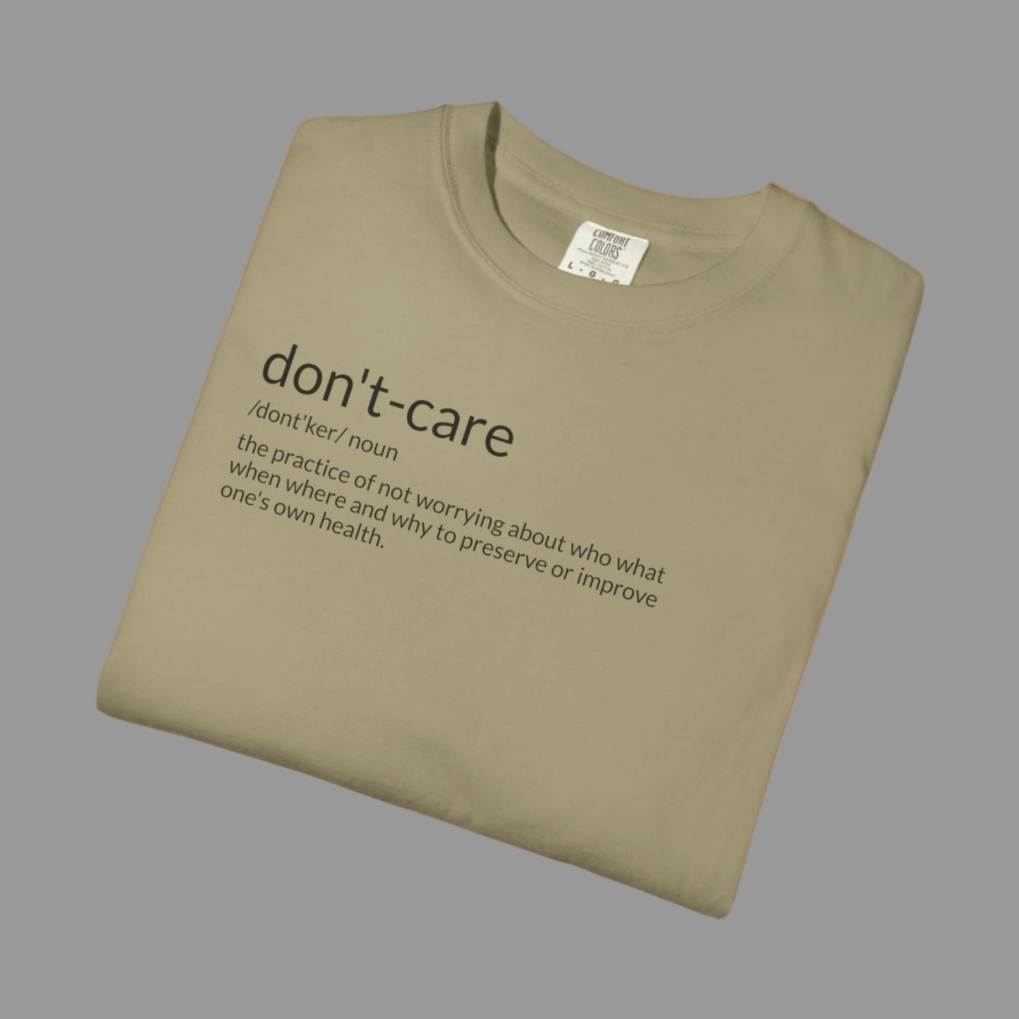 Folded khaki t-shirt with 'don't-care' text on a white background