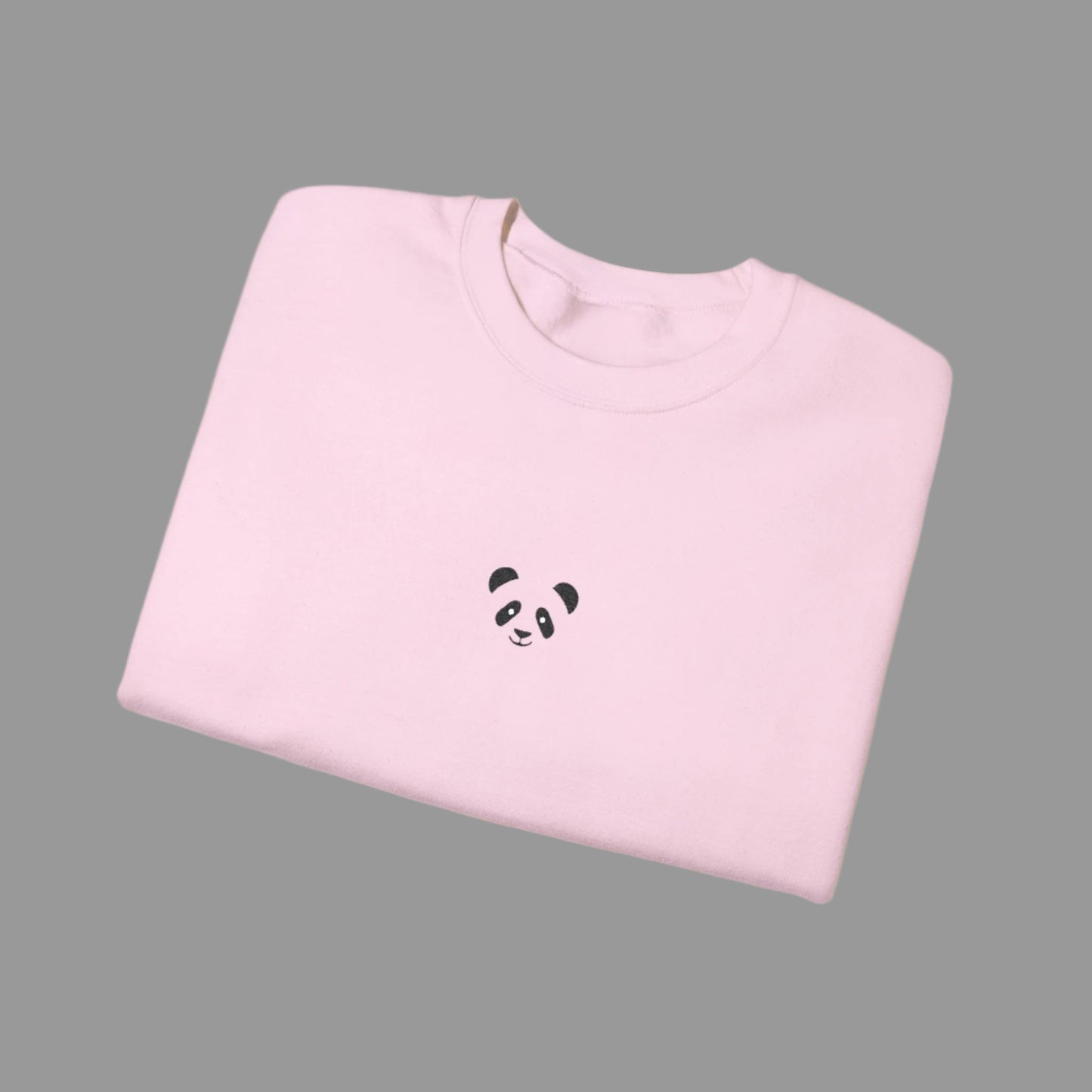 Folded pink sweatshirt with a panda design on a white background