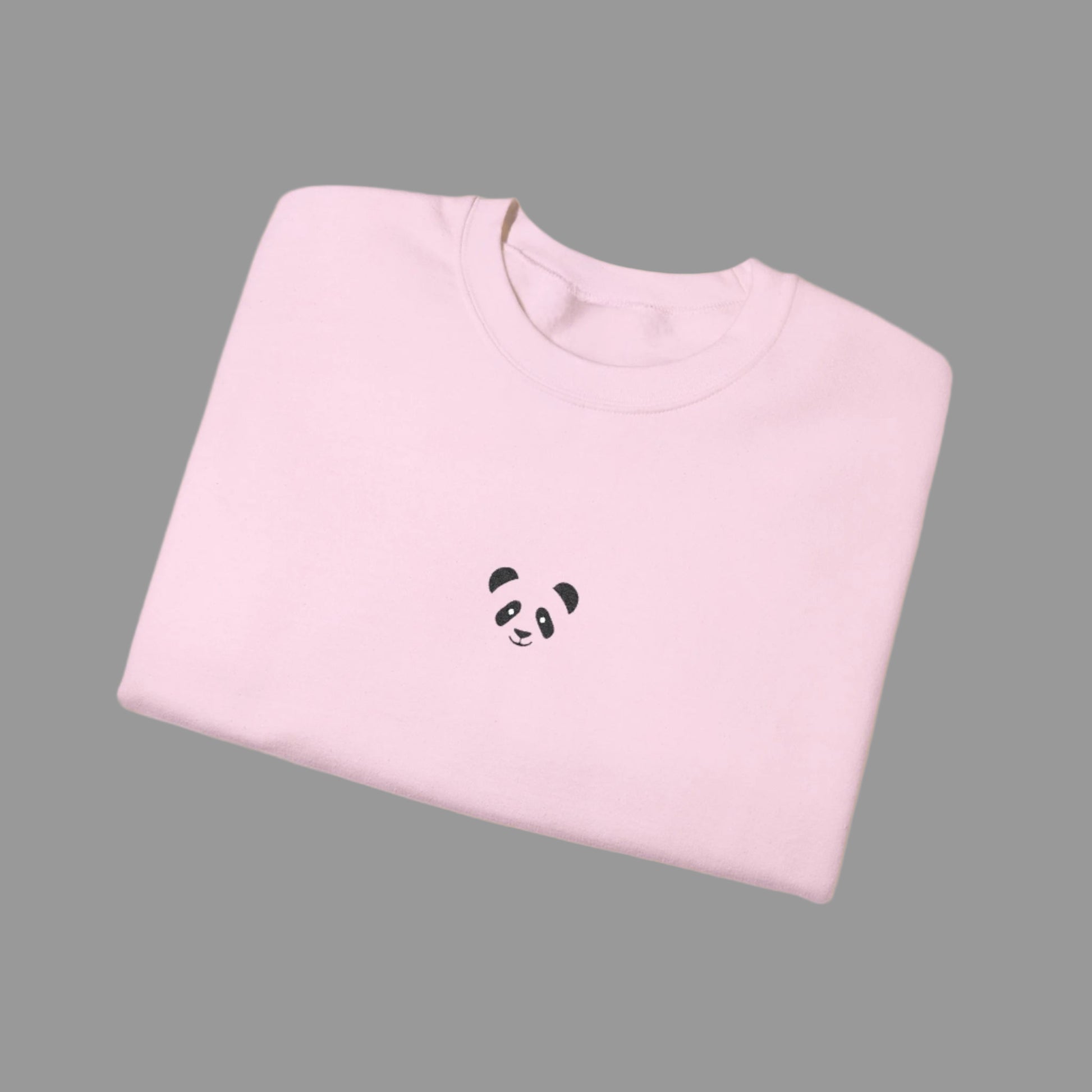 Folded pink sweatshirt with a panda design on a white background
