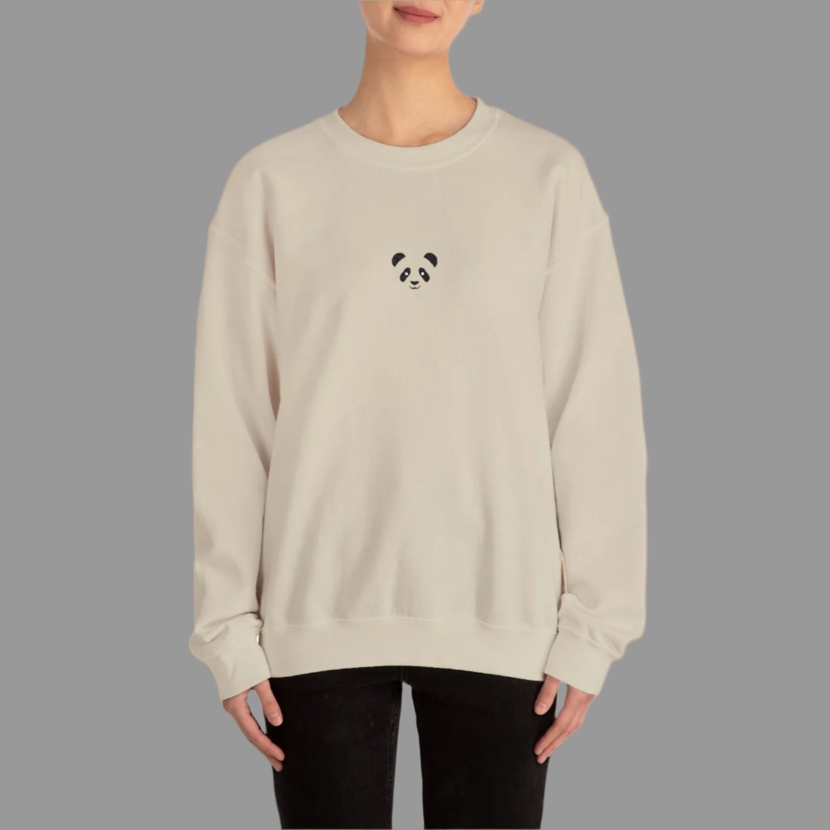 Person wearing a beige sweatshirt with a panda design on a white background