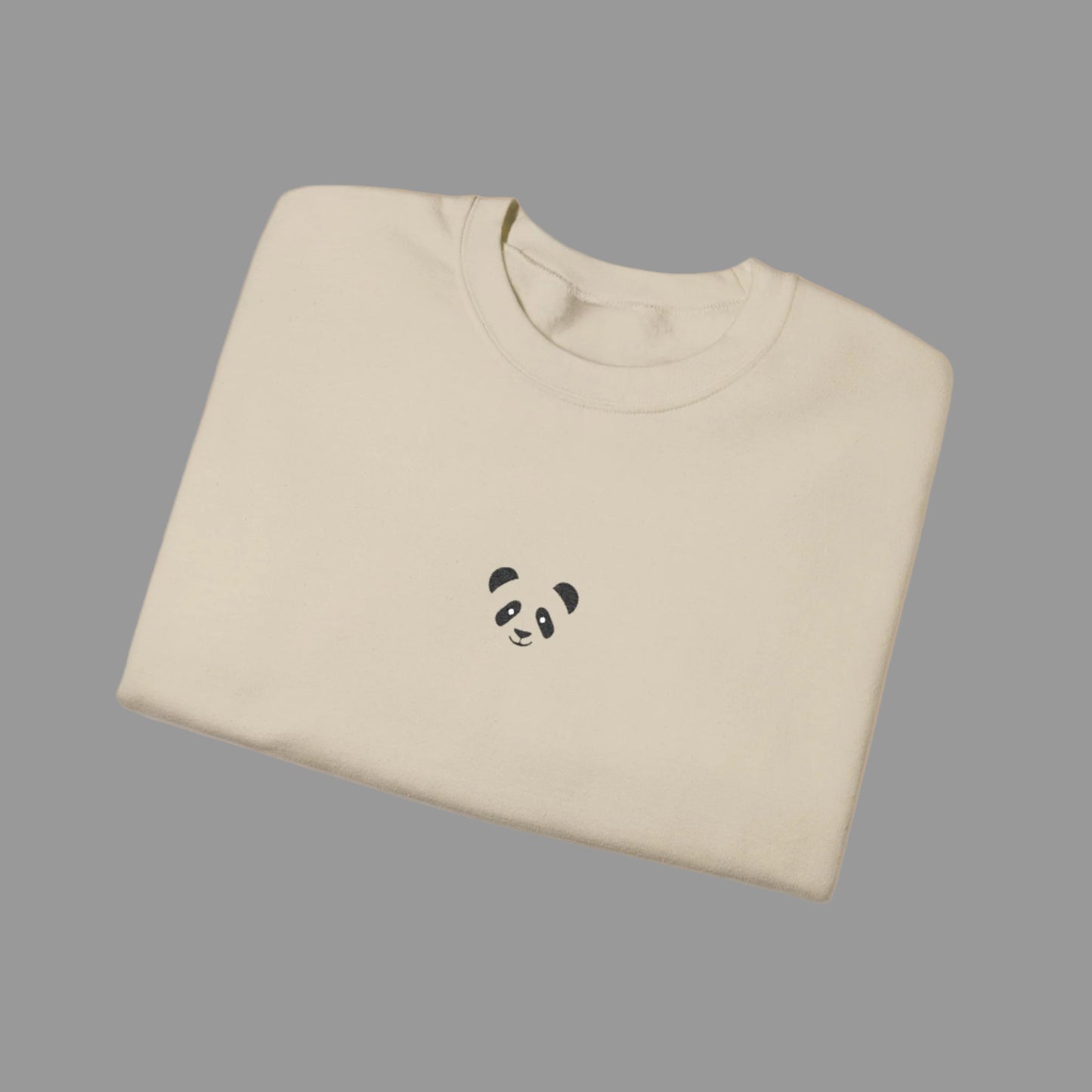 Folded beige sweatshirt with a panda design on a white background