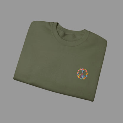 Folded green sweatshirt with a colorful peace symbol design on a white background