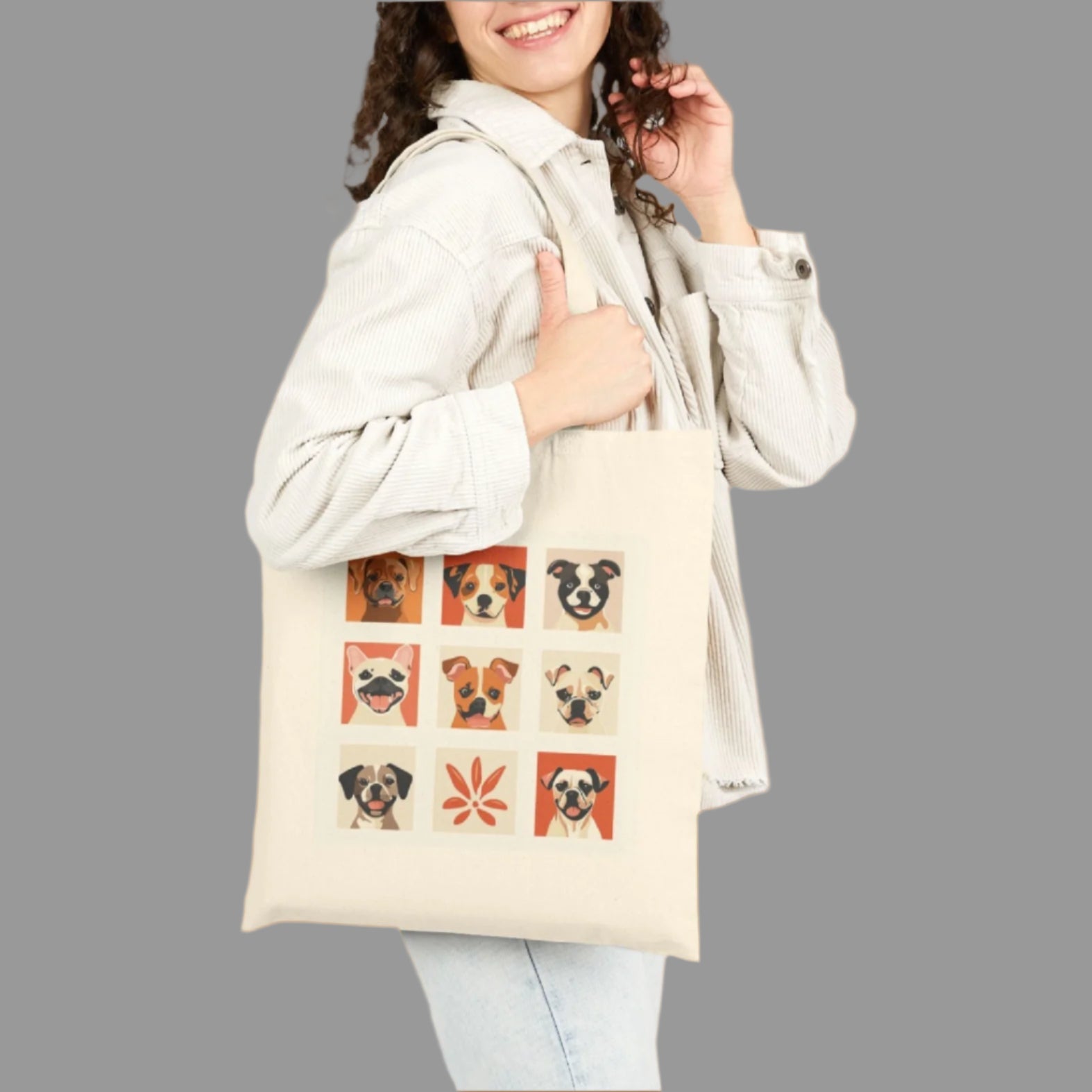 Woman holding a tote bag with dog illustrations on a white background