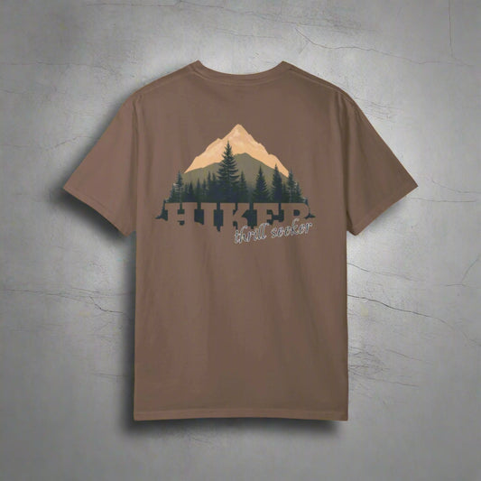Brown t-shirt with a mountain and tree graphic on the back, on a white background