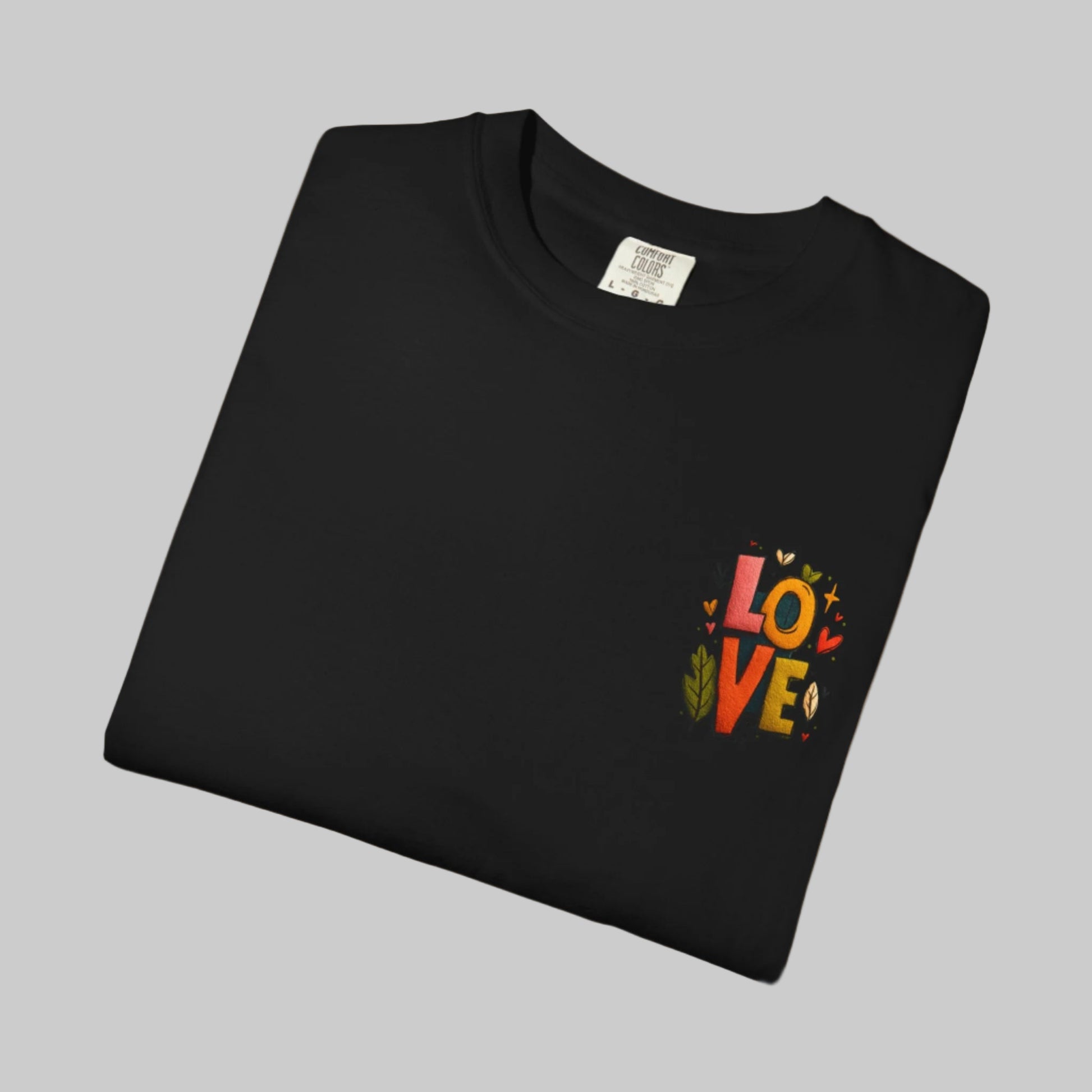 Folded black t-shirt with colorful 'LOVE' design on a white background