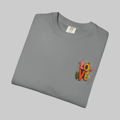 Folded gray t-shirt with colorful 'LOVE' design on a white background
