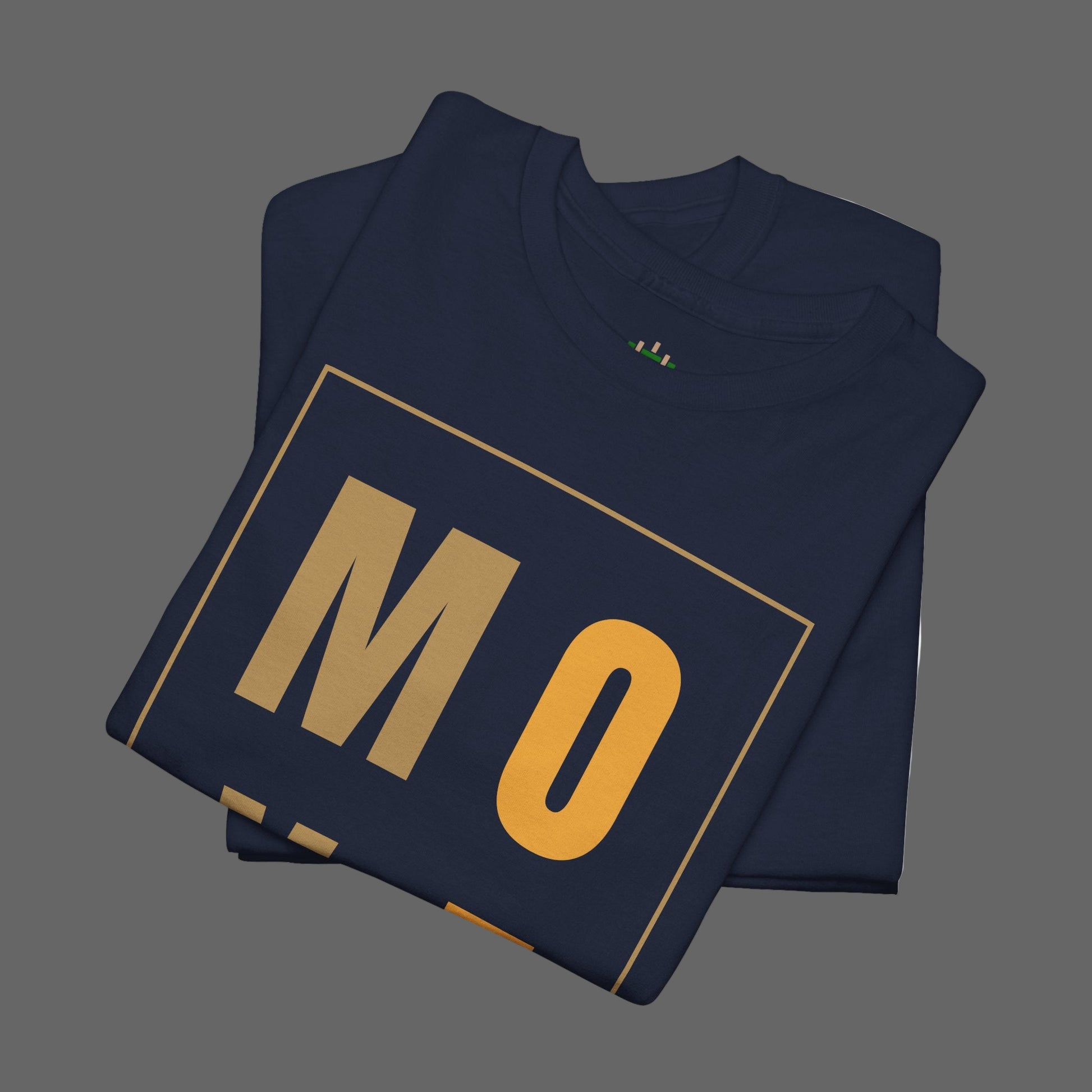 Folded navy blue shirt with 'MO' printed in gold on a white background
