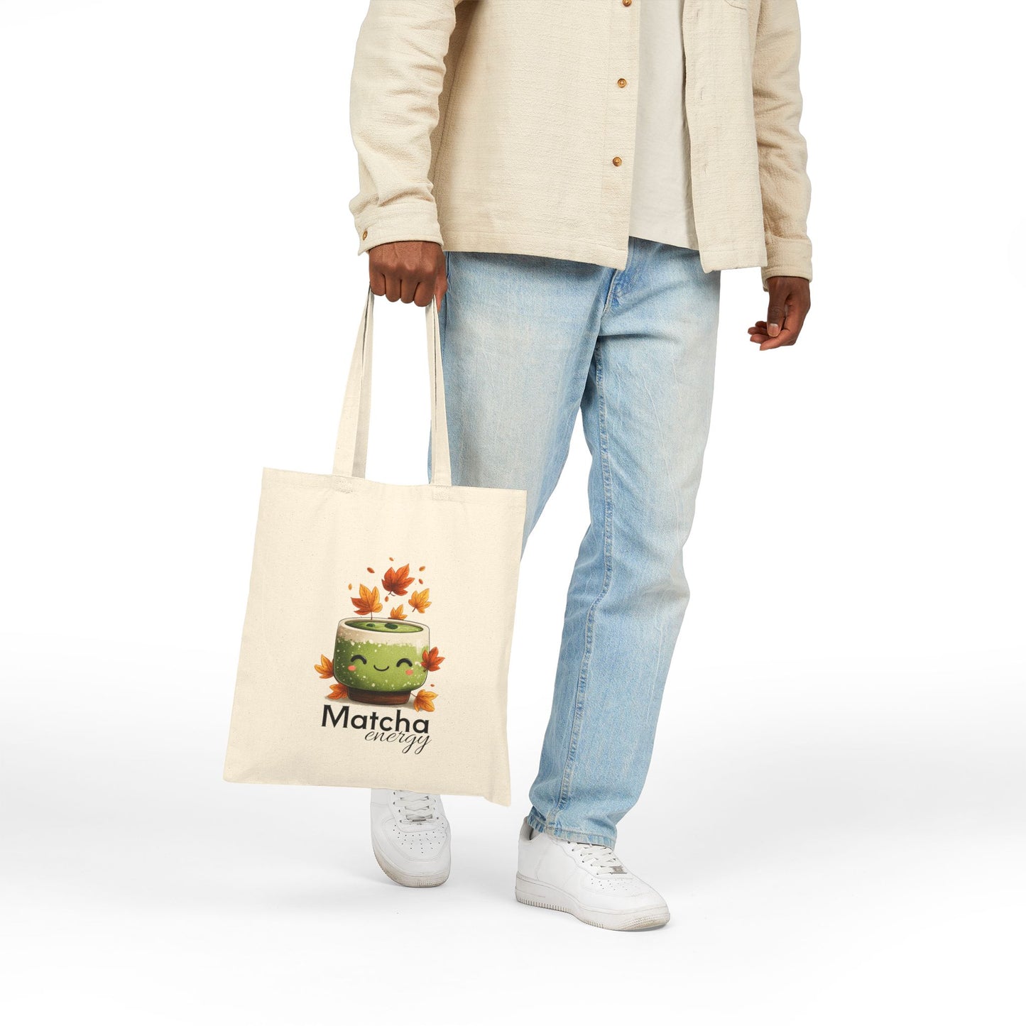 Person holding a tote bag with a matcha-themed design on a white background