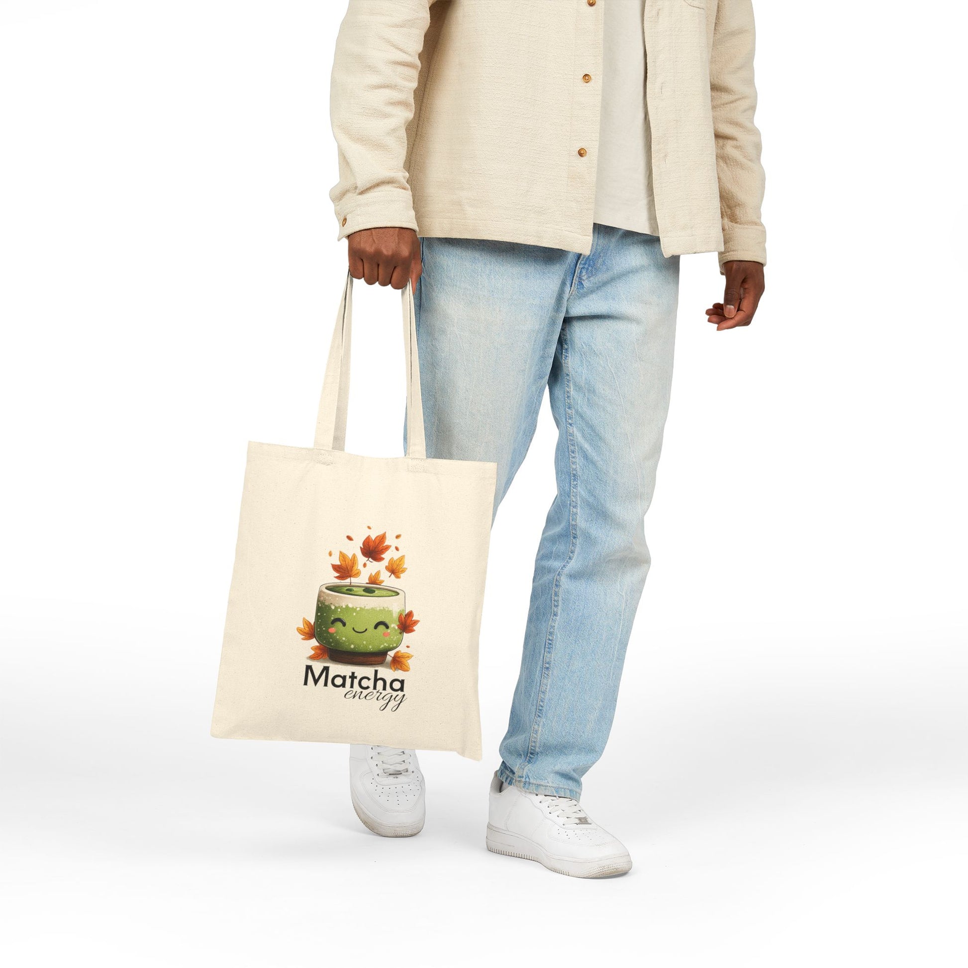 Person holding a tote bag with a matcha-themed design on a white background