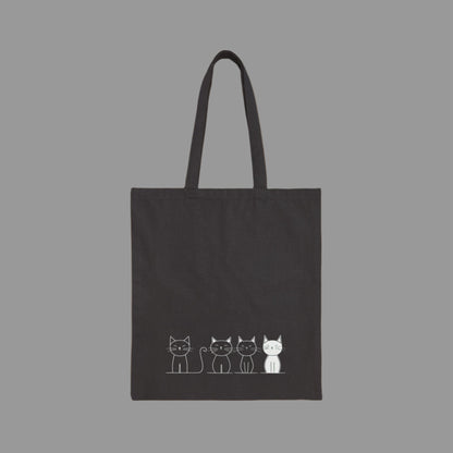 Black tote bag with white cat illustrations on a white background