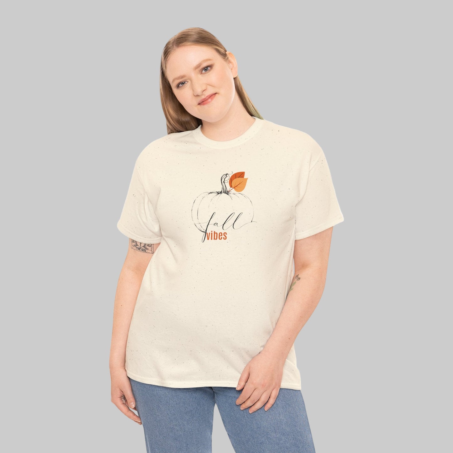 Woman wearing a cream t-shirt with 'fall vibes' design on a white background