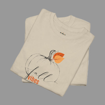 Beige t-shirt with pumpkin and leaf design and 'Fall vibes' text on a white background