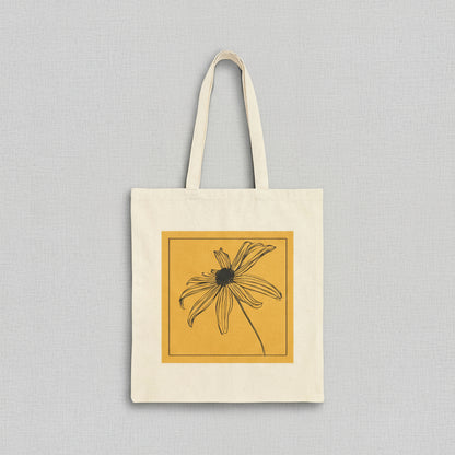 Tote bag with a black and white flower design on a yellow background