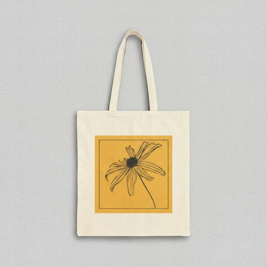 Tote bag with a black and white flower design on a yellow background