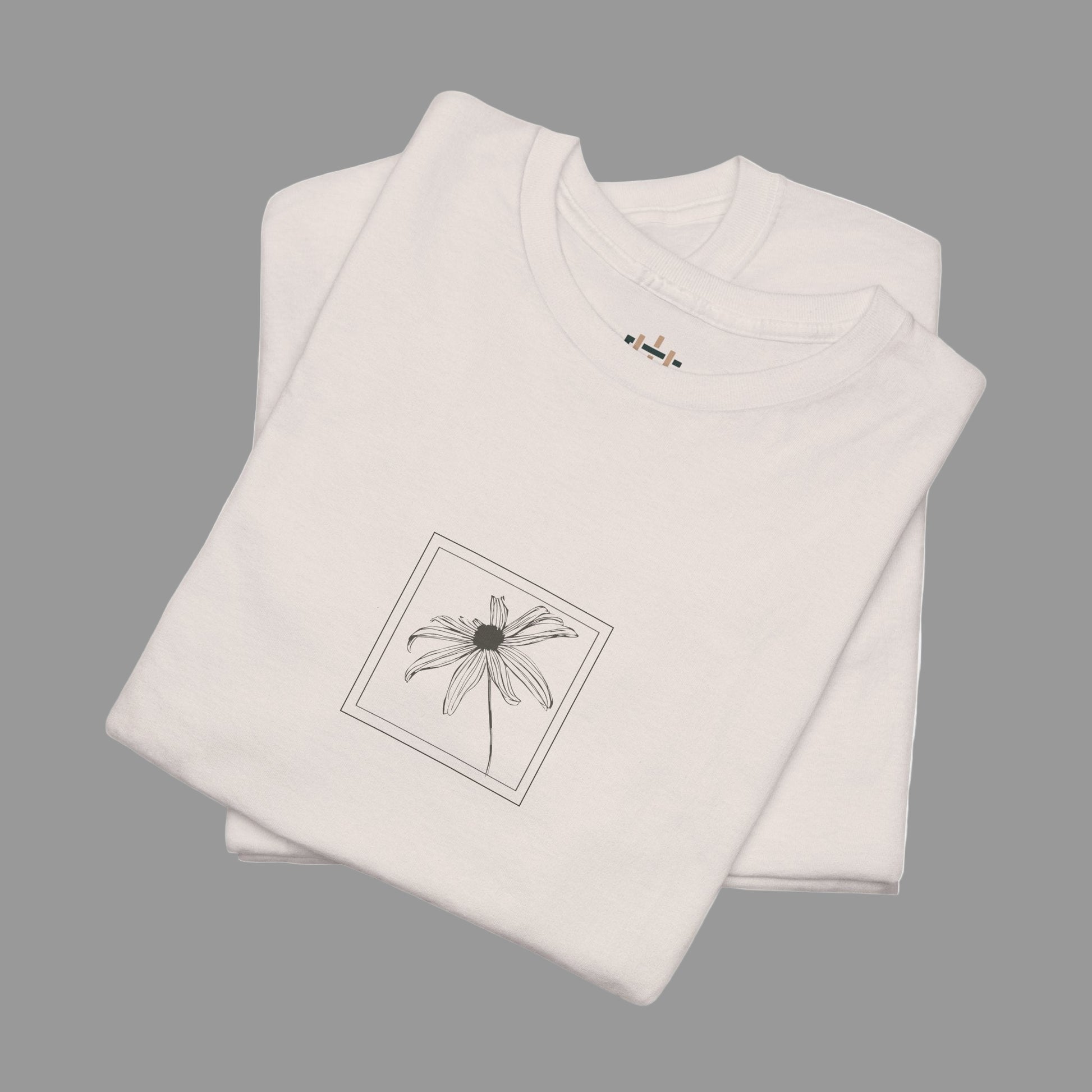 Folded beige t-shirt with a black floral design on a white background