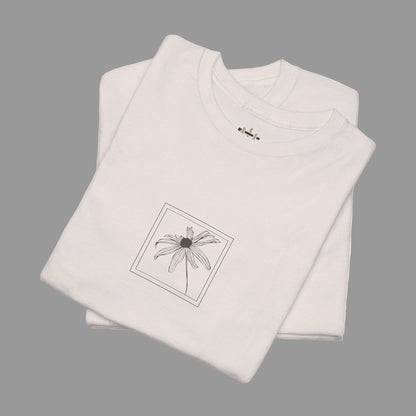 Folded beige t-shirt with a black floral design on a white background