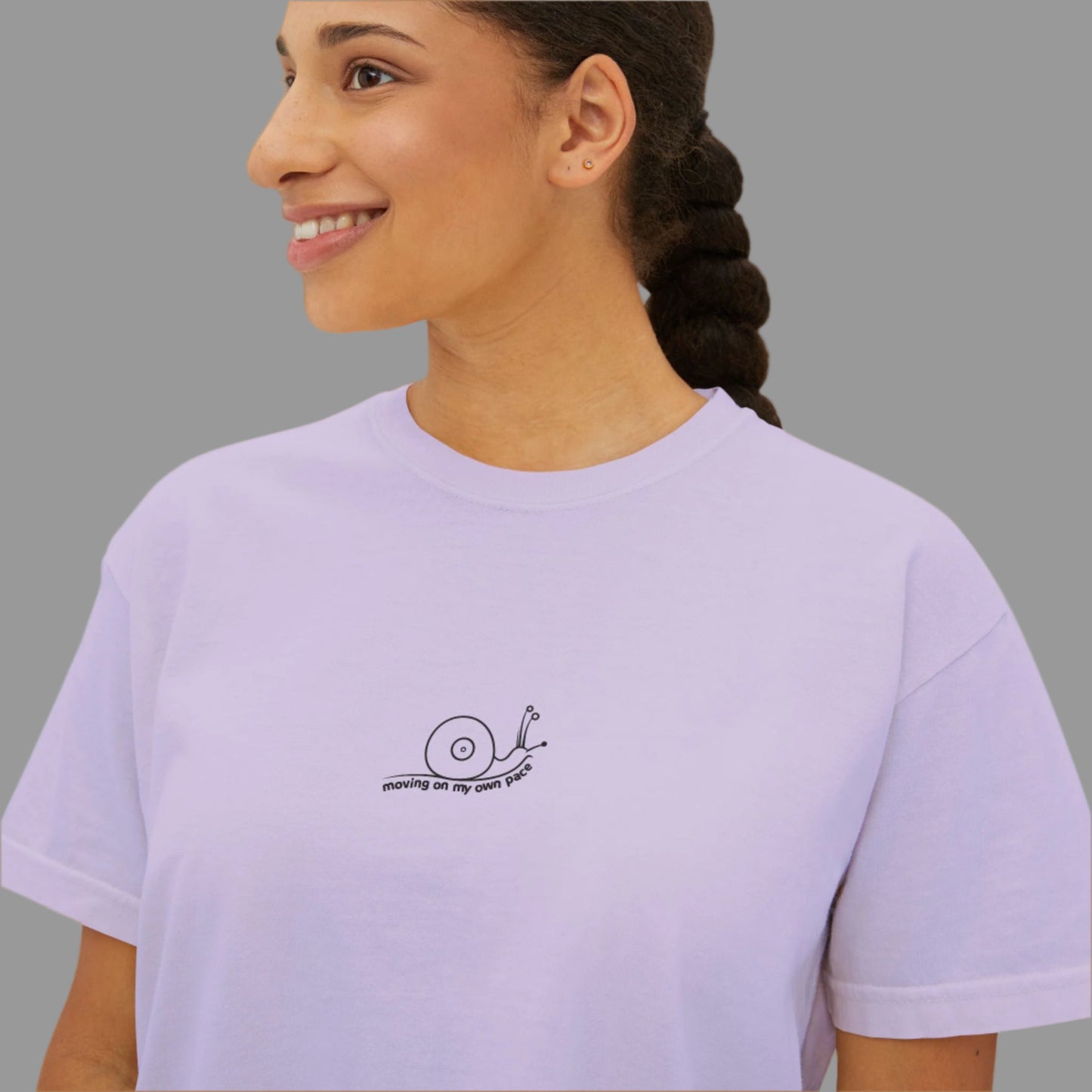 Woman wearing a light purple t-shirt with a small logo on a white background