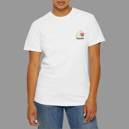 Person wearing a white t-shirt with a small graphic on a plain background