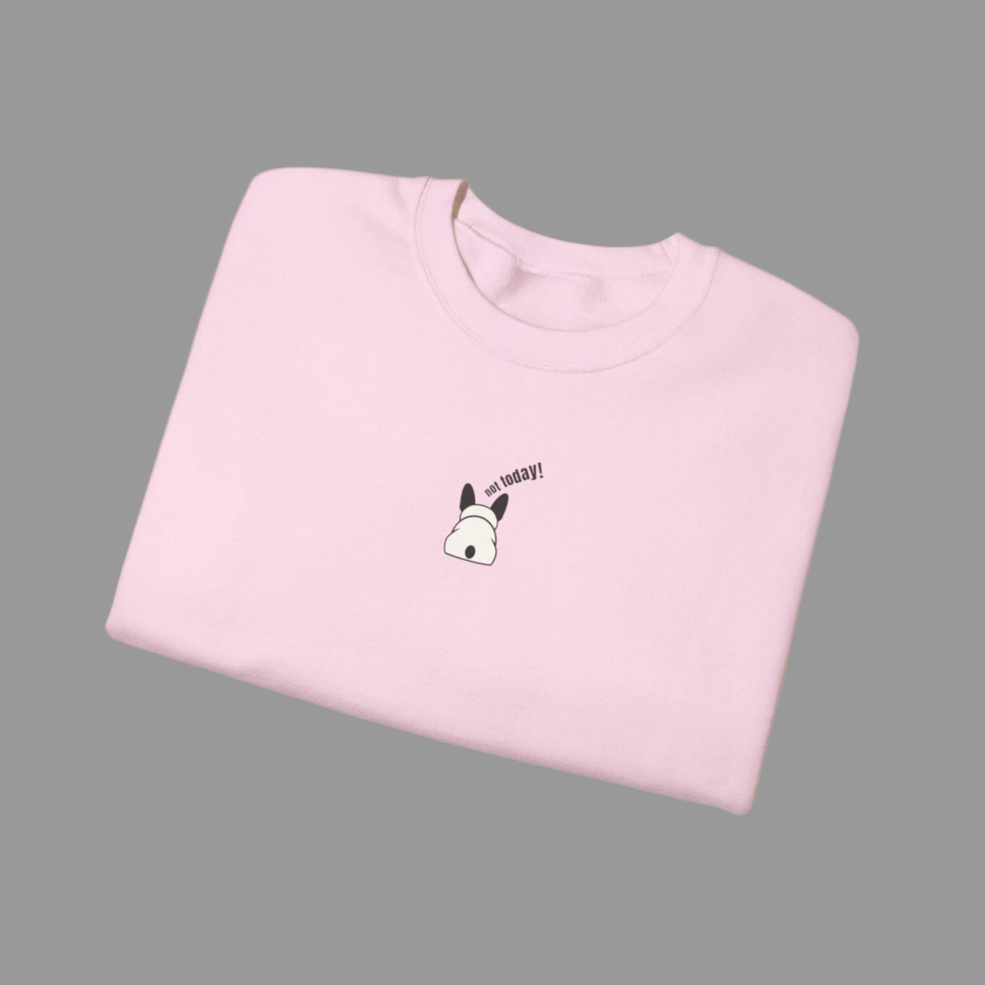 Folded pink t-shirt with a small graphic and text on a white background