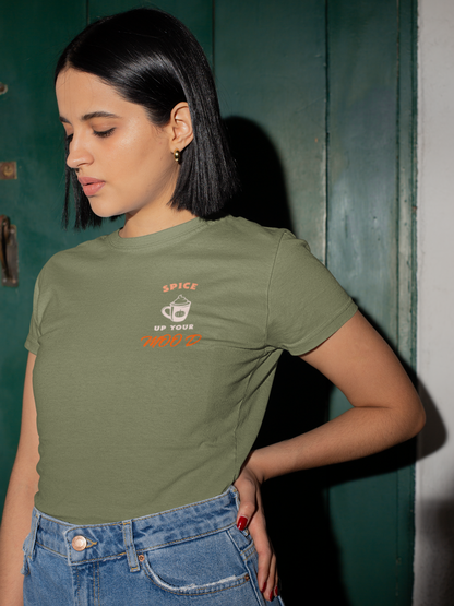 Woman wearing a green t-shirt with text against a green wall.