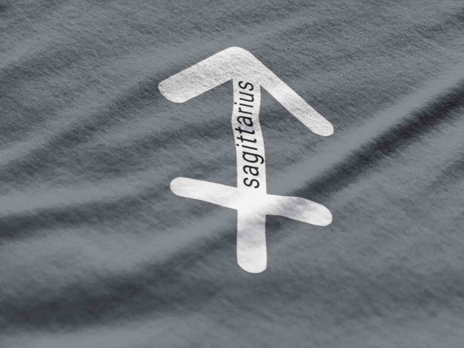 White Sagittarius zodiac symbol on gray fabric
