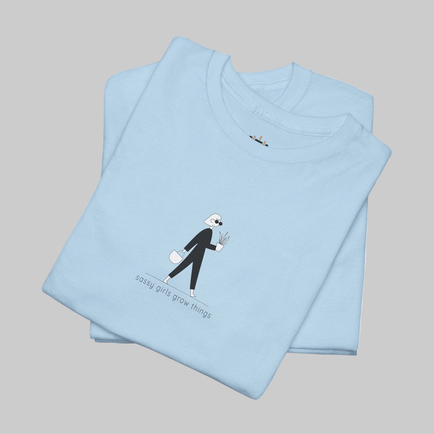 Folded light blue t-shirt with a graphic design and text on a white background