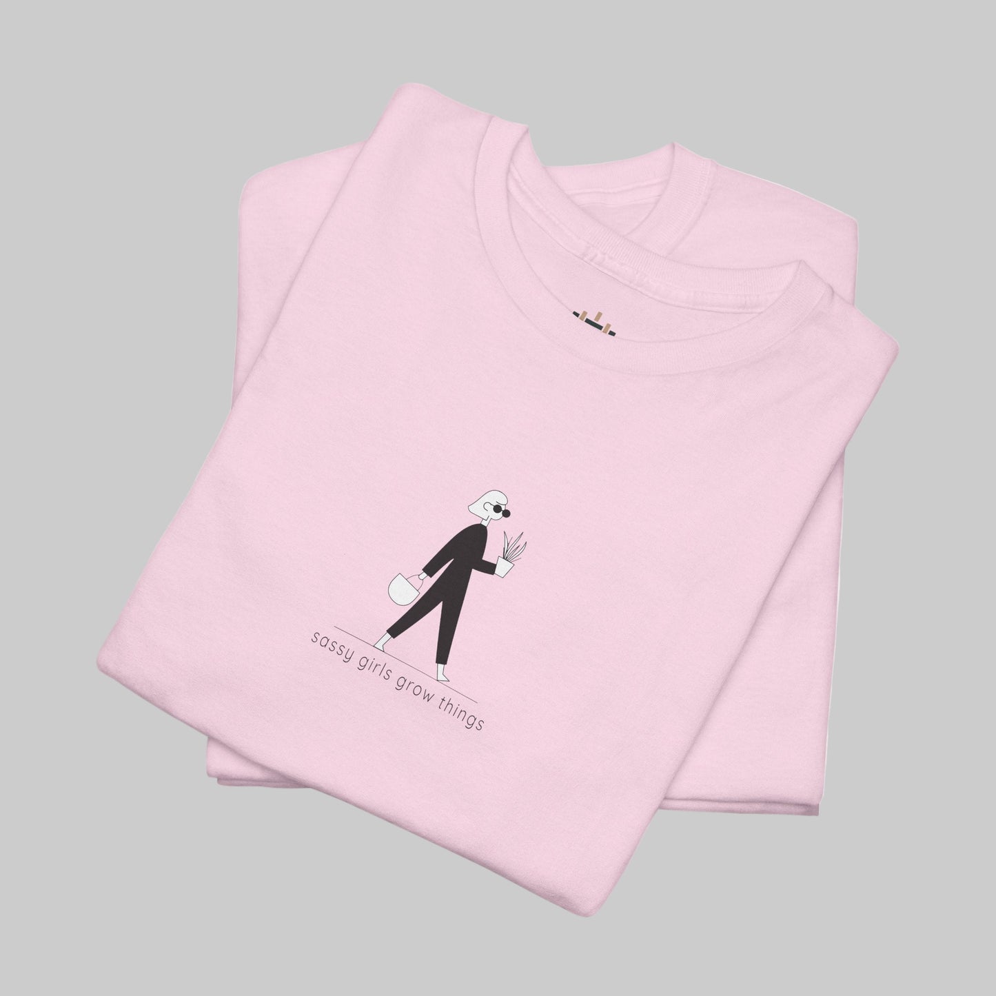Folded pink t-shirt with a graphic design and text on a white background
